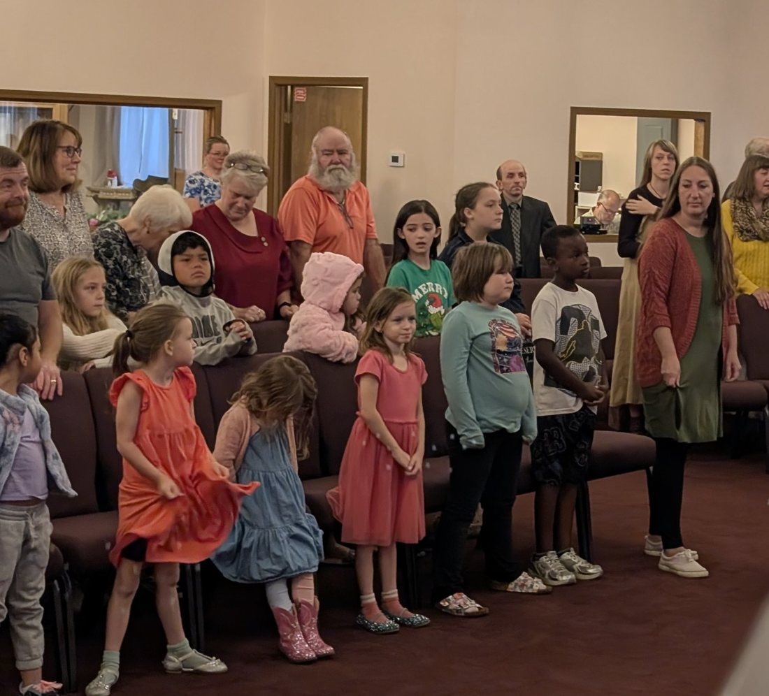 Children and families standing together during a Sunday service